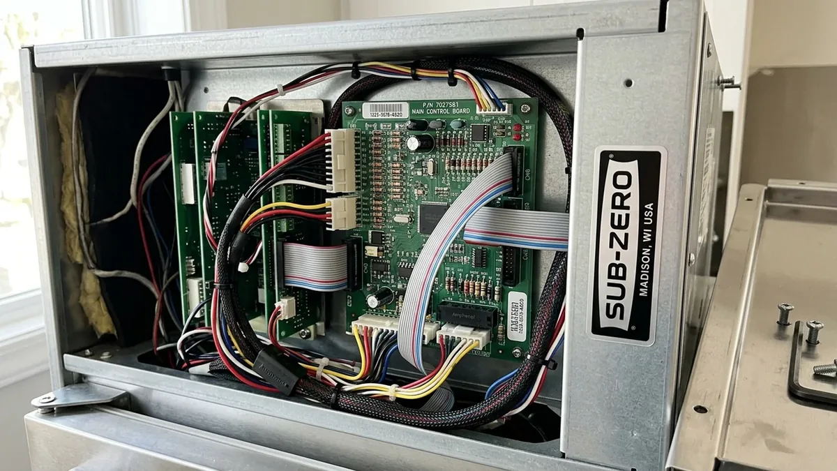 Open electrical compartment of a Sub-Zero refrigerator showing the control board and wiring